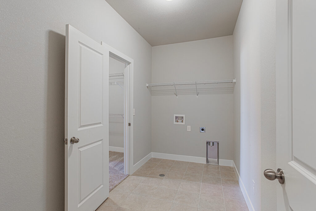Laundry room with tiled floor, wall hookups, and a door to a closet or adjoining room.