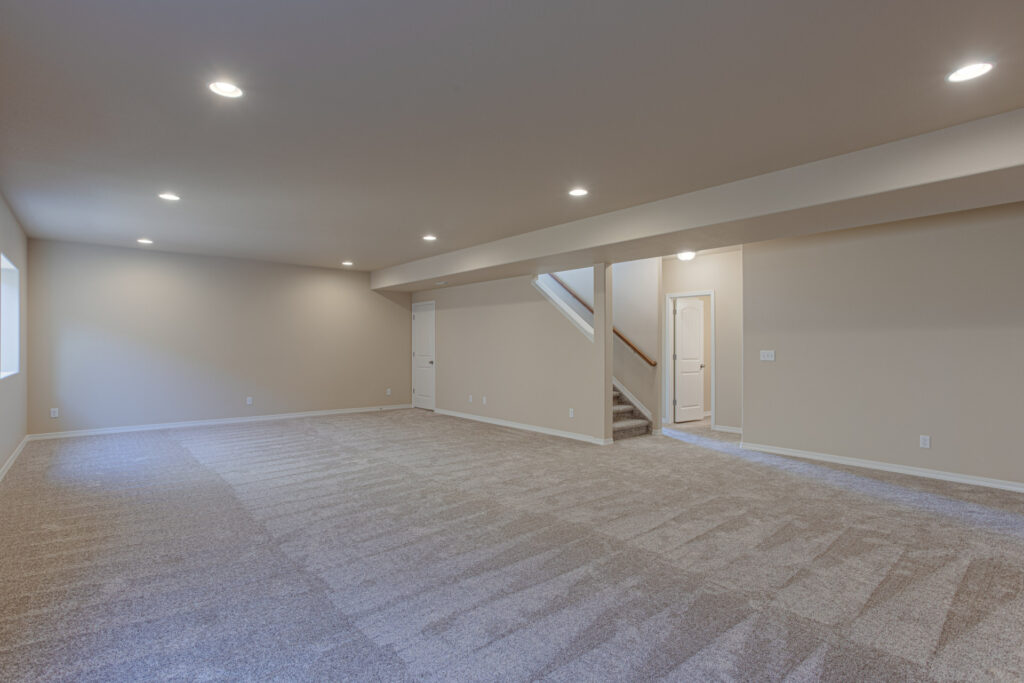 Large finished basement or rec room with recessed lighting and carpeted floor.