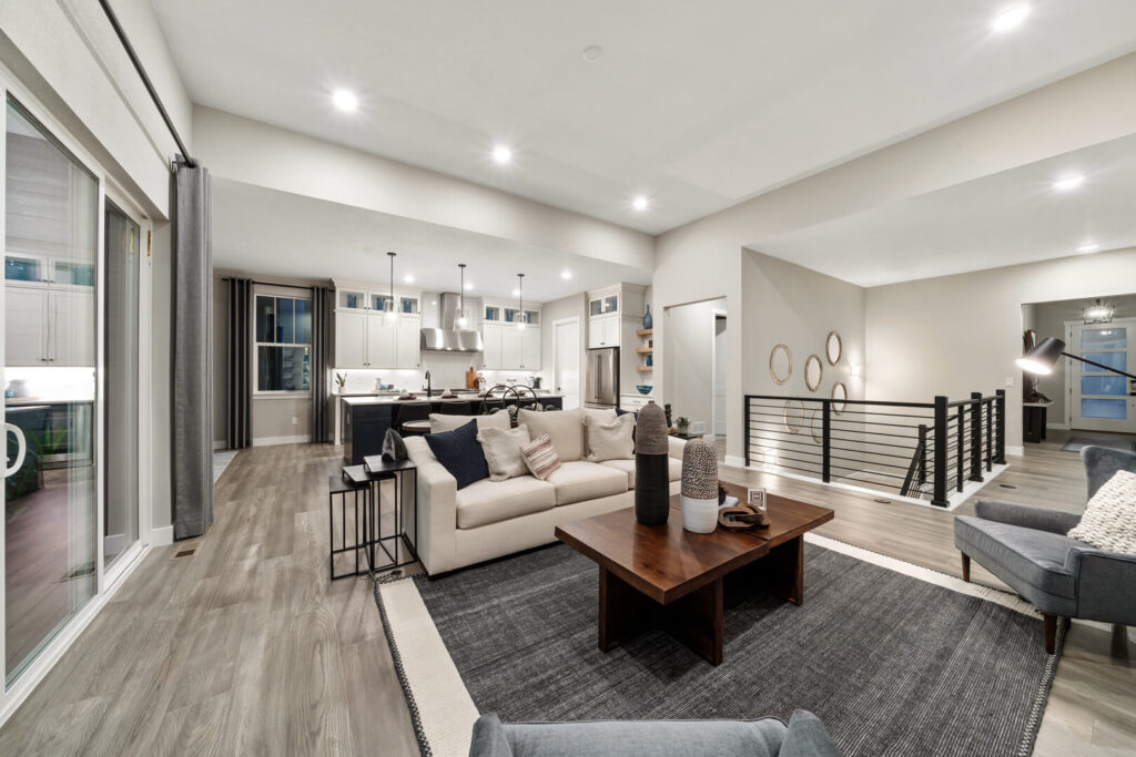 Wide view of a furnished living room and kitchen with sliding glass door to the left.