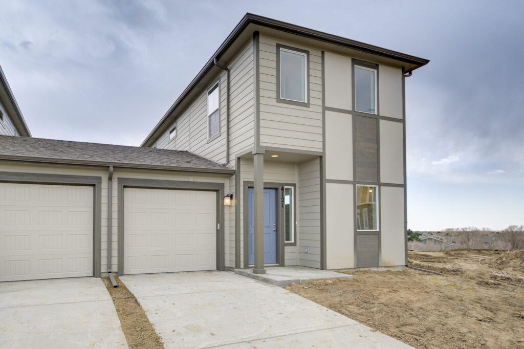 Close-up front entry of a two-story home featuring a blue door and two-car garage.
