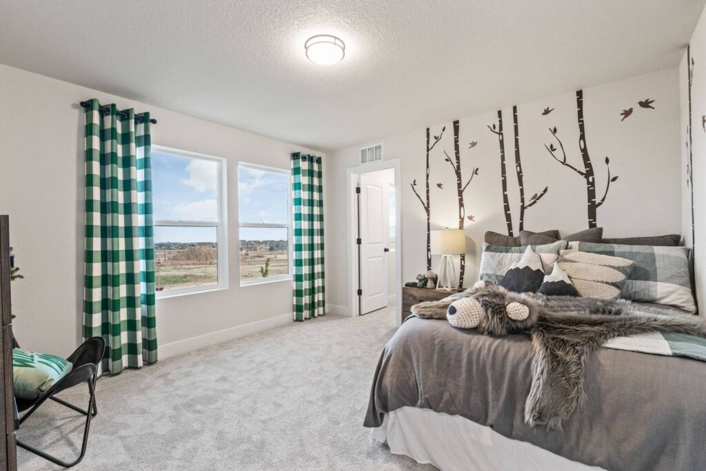 Bright bedroom with twin windows, green check curtains, and nature wall decals.