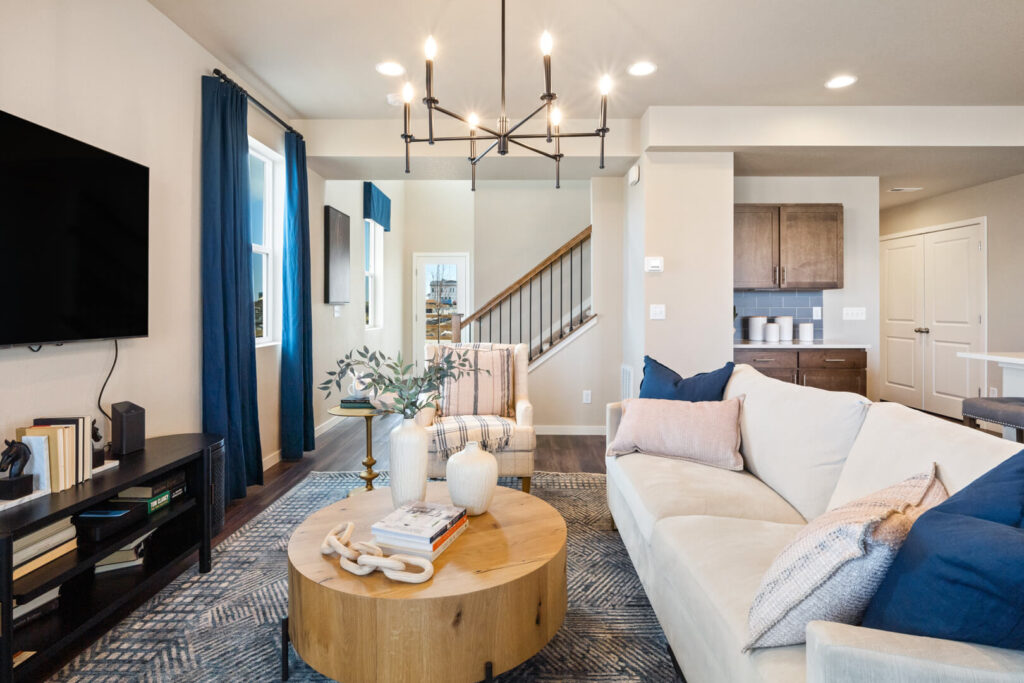 Cozy living room view with sofa, coffee table, TV, and staircase in the background.
