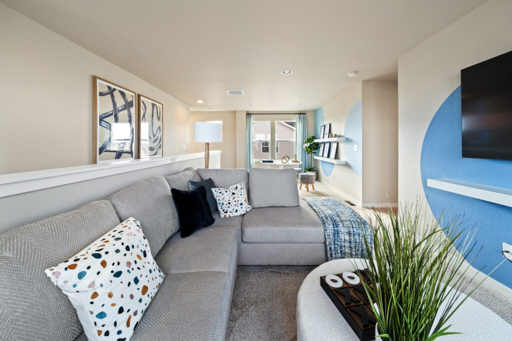 Cozy sectional sofa in a loft with patterned pillows, ottoman and decorative accents.