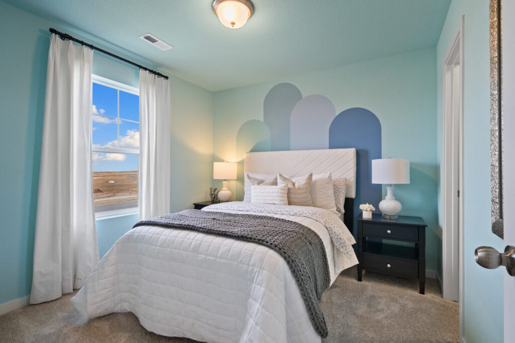 Small bedroom with teal walls, white bed linens, and arc-shaped mural behind headboard.