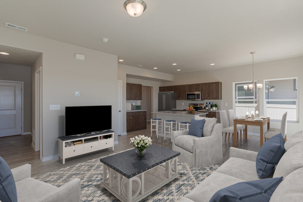 Open-plan living area with seating, TV stand, kitchen island and barstools.