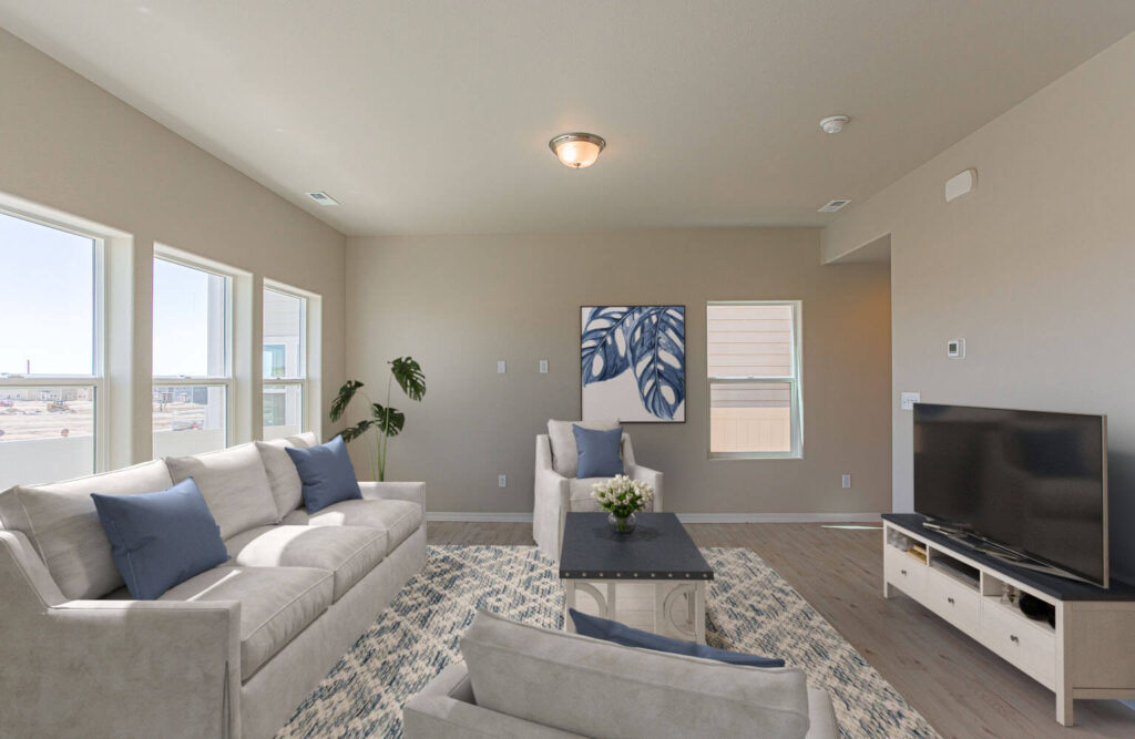Bright living room with multiple windows, sofa seating and decorative wall art.
