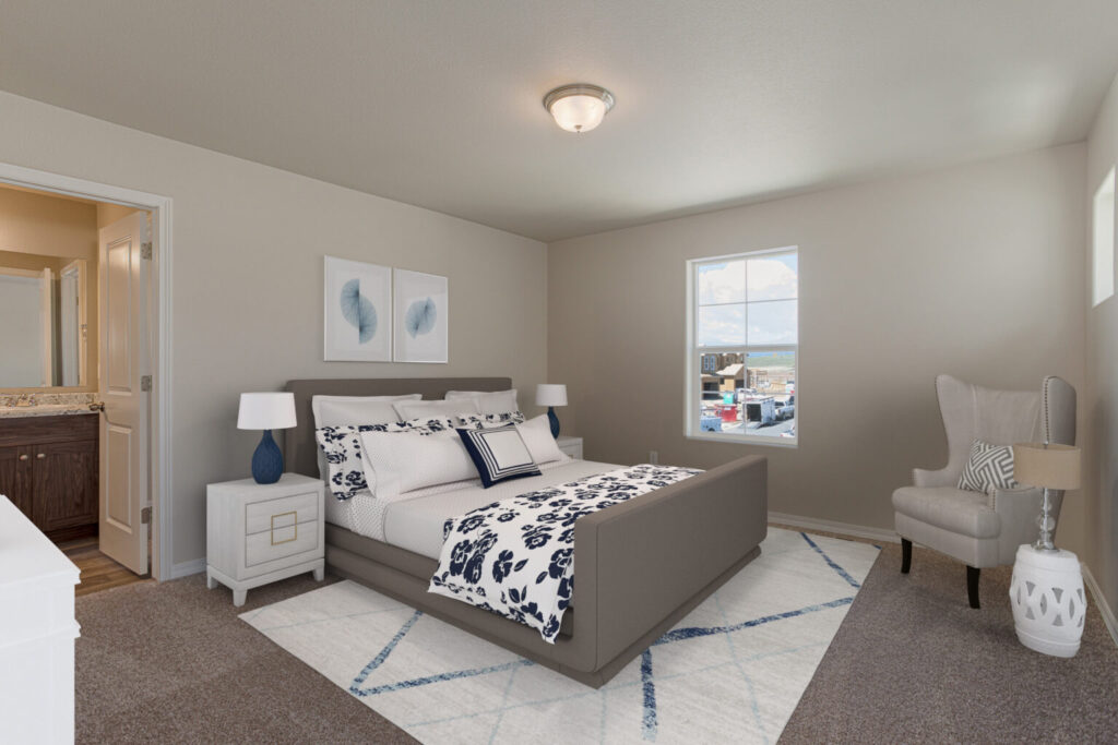 Bedroom with gray upholstered bed, patterned bedding, nightstands and a wingback chair near a window.