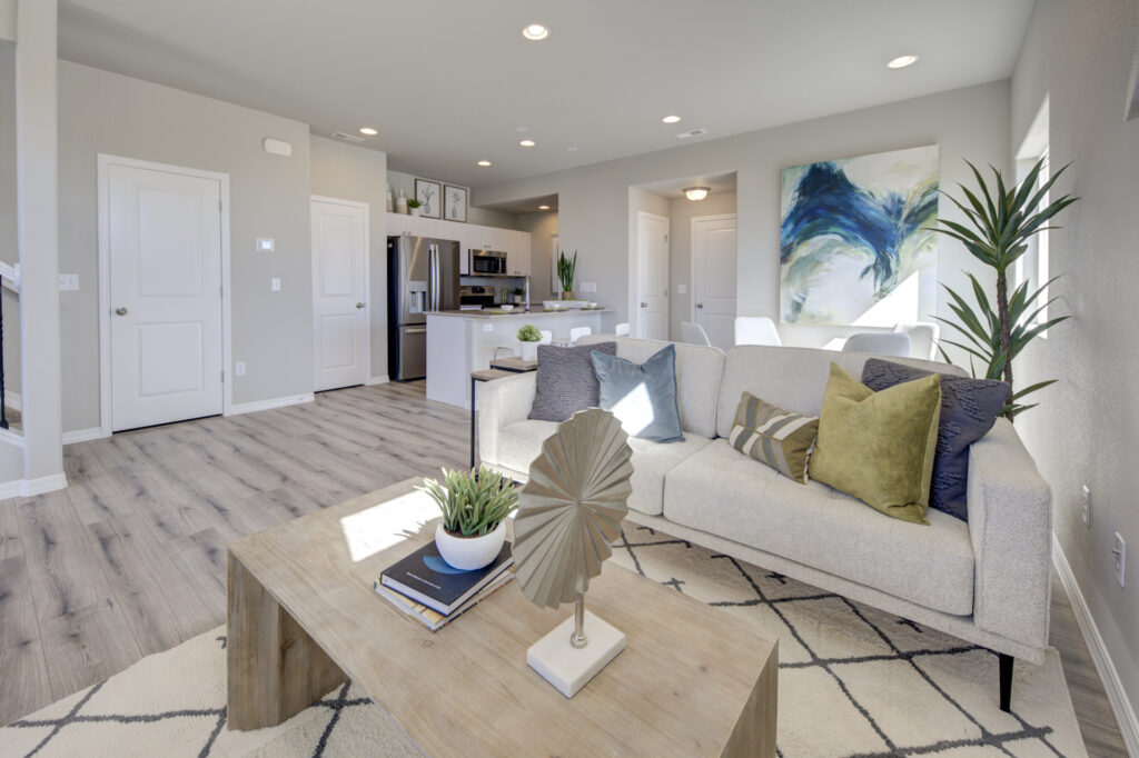 Living area focused on a coffee table and sofa, with kitchen and doors visible in background.