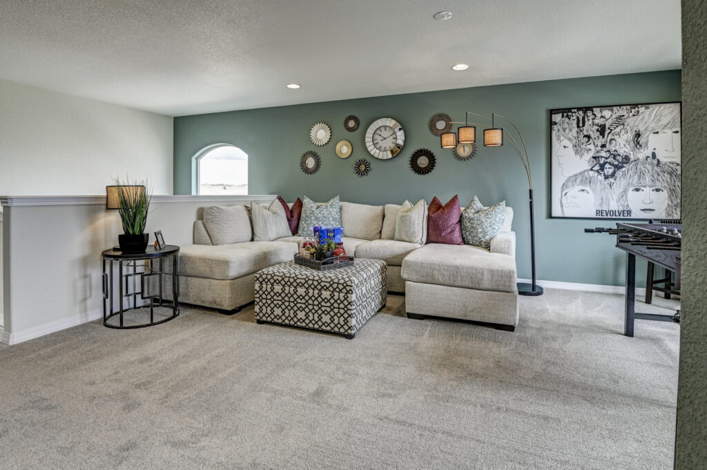 Cozy family nook with sectional sofa, gallery of circular wall decor and a Revolver album print.