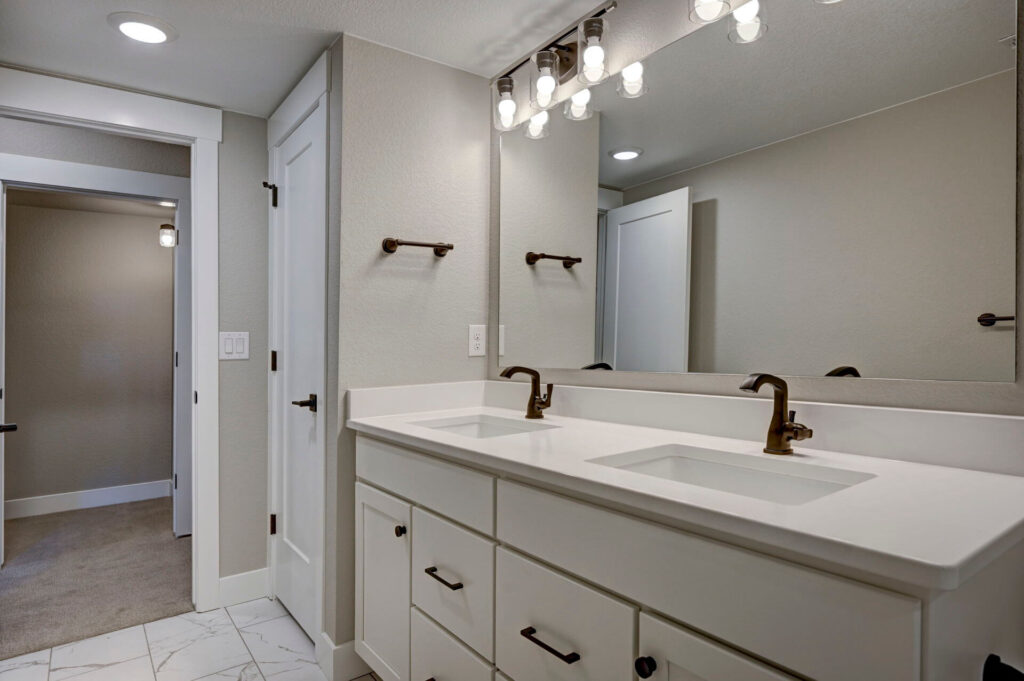 Double-sink vanity and large wall mirror in a neutral-toned bathroom.