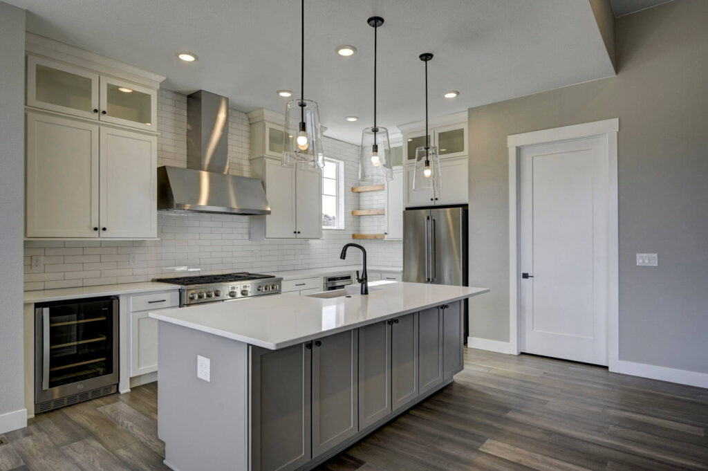 Kitchen perspective showing island sink, stainless appliances, and open shelving by a window.