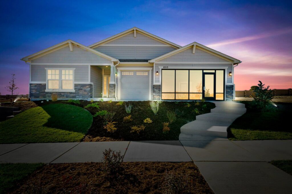 Single-story house exterior at dusk with illuminated windows and a curved front walkway.