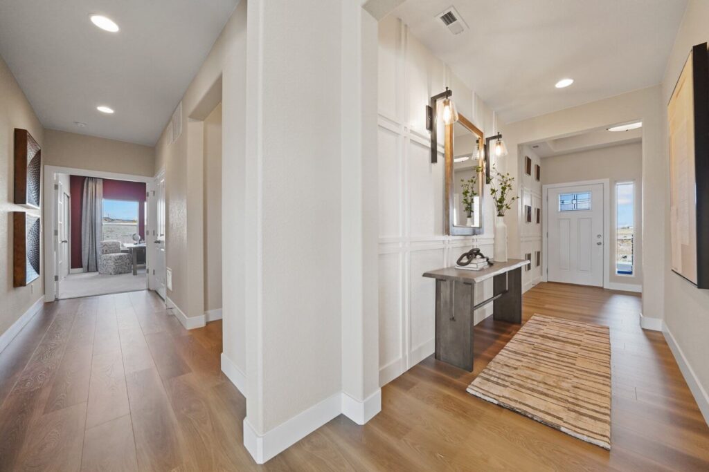 Home entry hallway with wood-look flooring, console table, and view toward a front door.