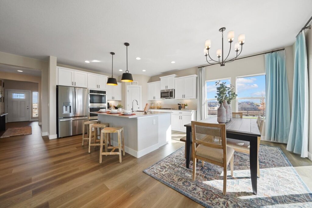 Kitchen and dining nook with island seating, stainless appliances, and a patterned area rug.