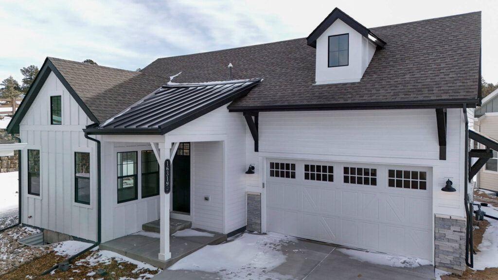 White modern farmhouse-style exterior with covered porch and two-car garage.