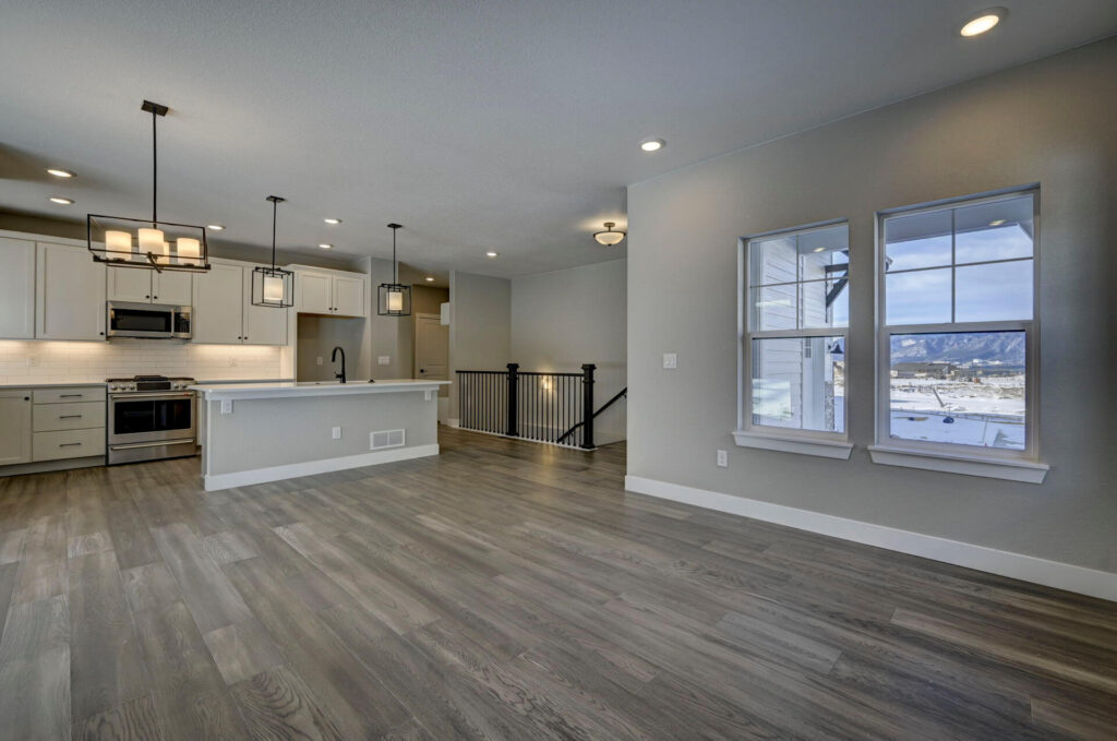 Open dining/kitchen area with windows overlooking snowy landscape and central island.