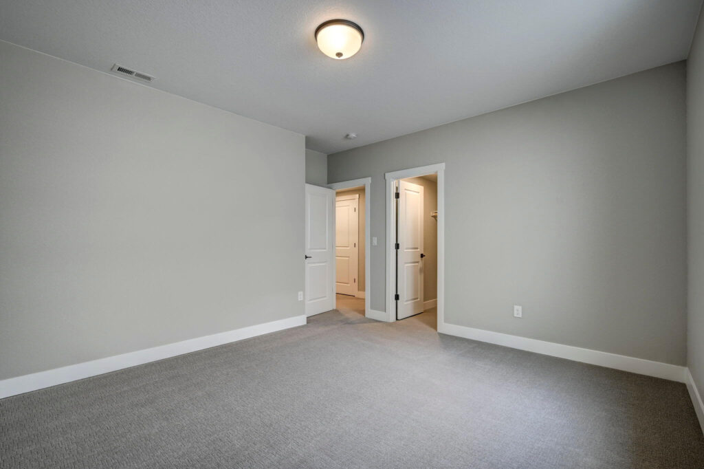 Unfurnished room showing two open doors and a ceiling light fixture
