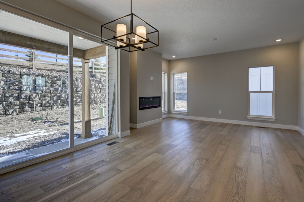 Dining or living space with modern square chandelier, sliding doors, and patio posts beyond glass.
