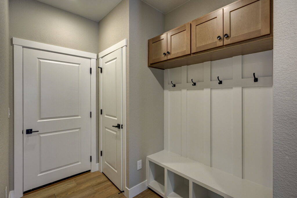 Entry or mudroom bench with cubbies, coat hooks, and upper storage cabinets.