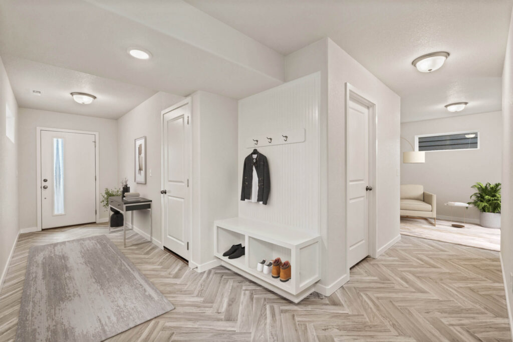 Bright entry or mudroom with built-in bench, coat hooks, and herringbone-pattern floor.