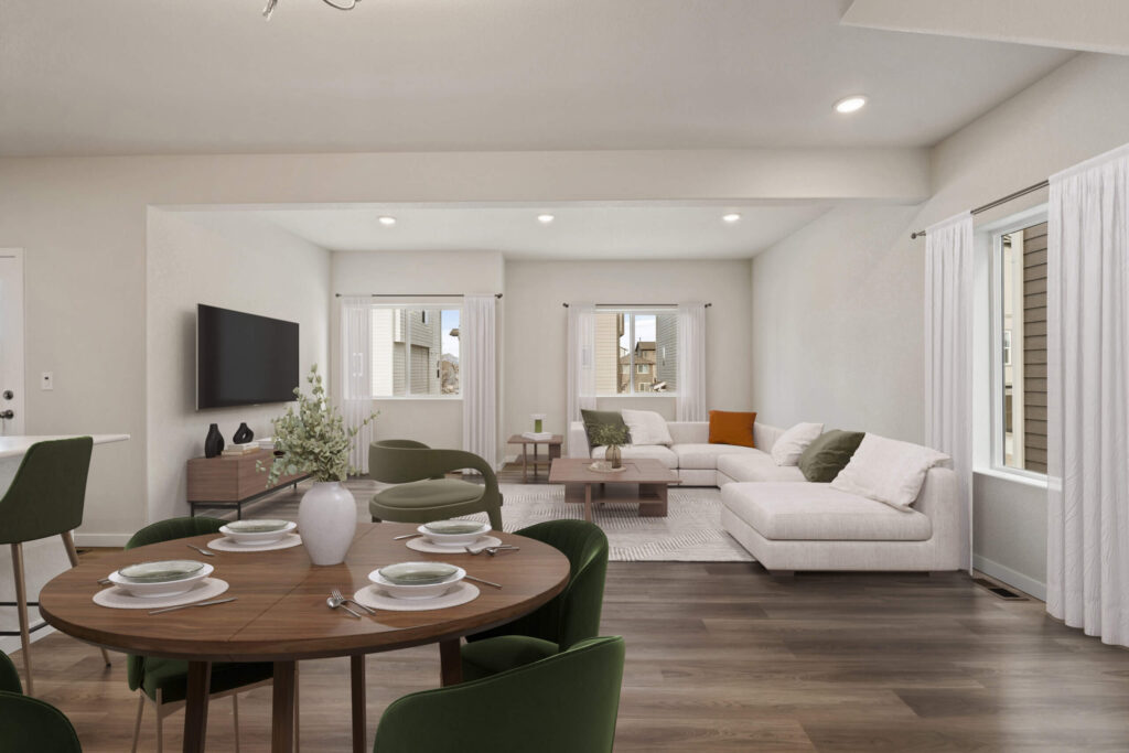 Combined dining and living room view with a round table in foreground and sectional sofa beyond.