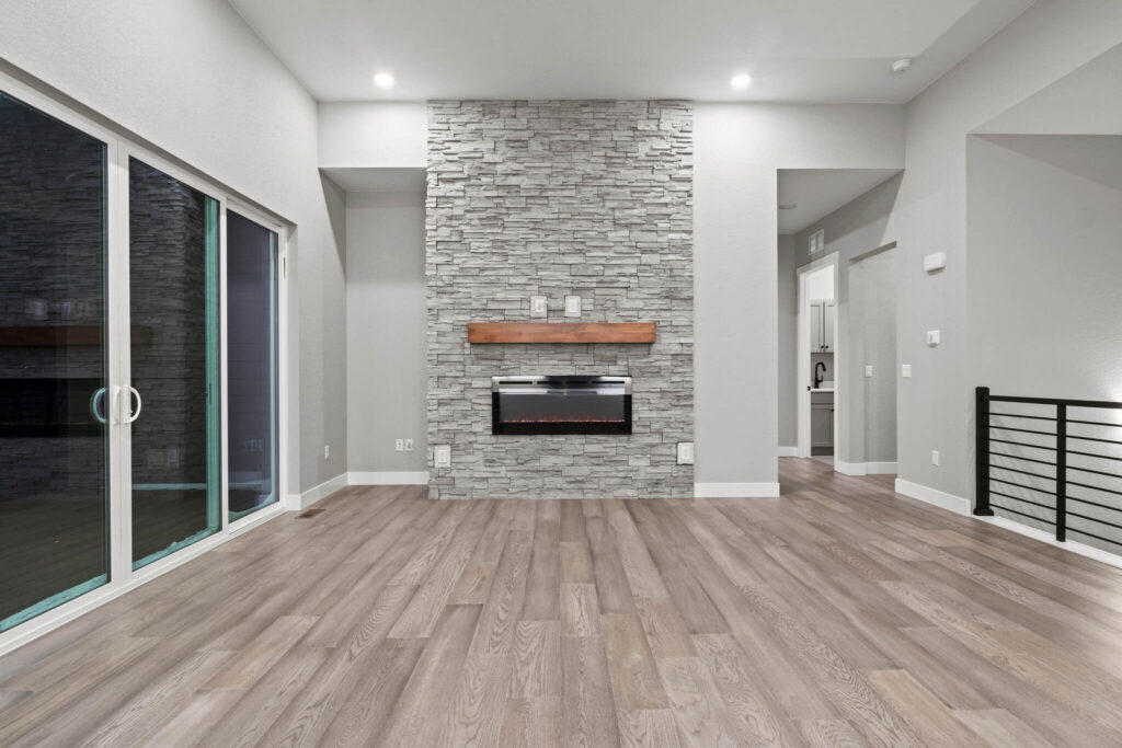 Straight-on view of a stone fireplace wall with electric fire and sliding glass doors to the left.
