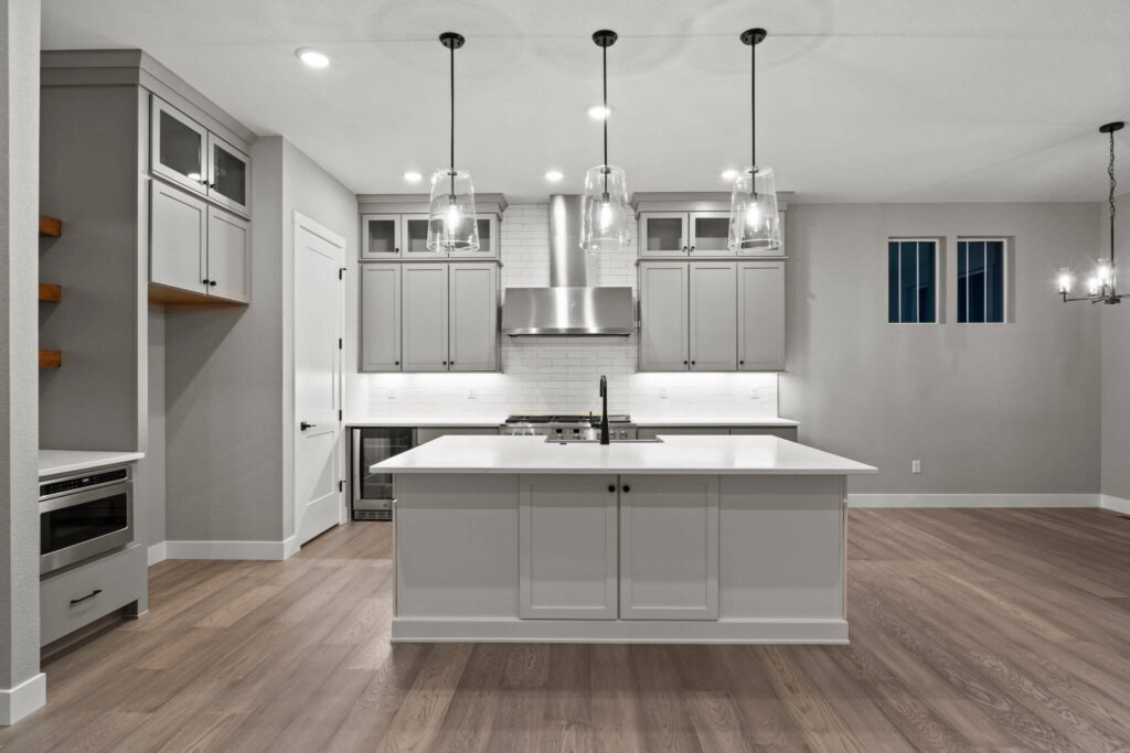 Contemporary kitchen with large center island, pendant lights, and stainless range hood.