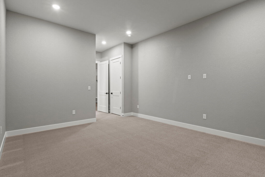 Unfurnished rectangular room with carpet, open door, and recessed ceiling lights.