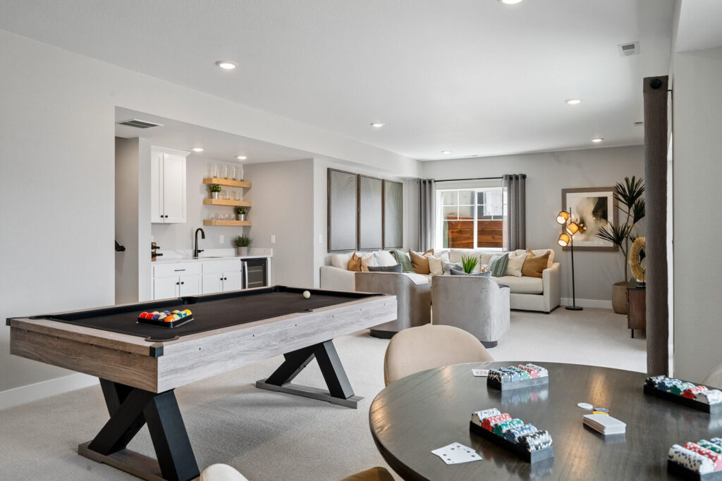 Recreation room with pool table, round poker table, and seating area by a window