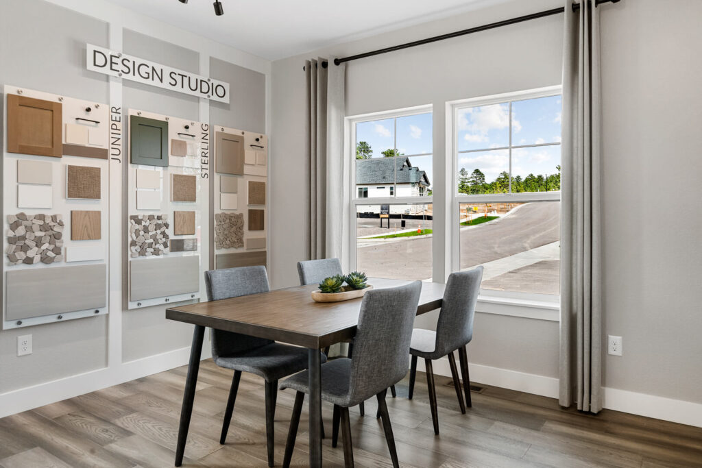 Small design studio or dining nook with table, four chairs, and wall-mounted design sample boards.