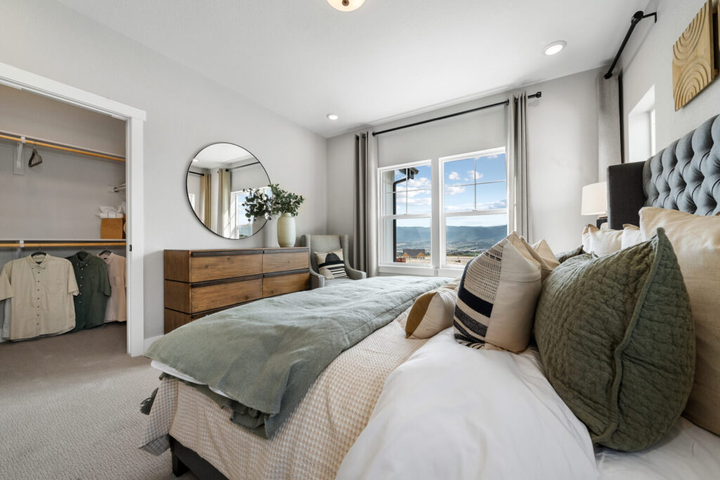 Bedroom showing bed, dresser, open closet, and a window with mountain views.