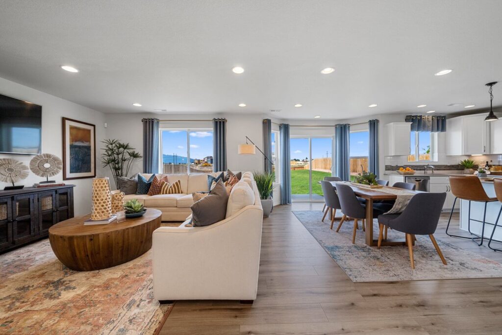 Open-plan living area with sectional sofa, dining table and sliding glass doors to backyard.