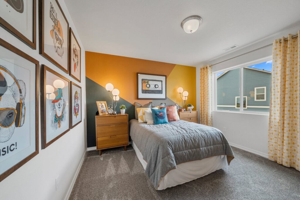 Bedroom with gray bed, mid-century nightstands, and geometric orange accent wall.