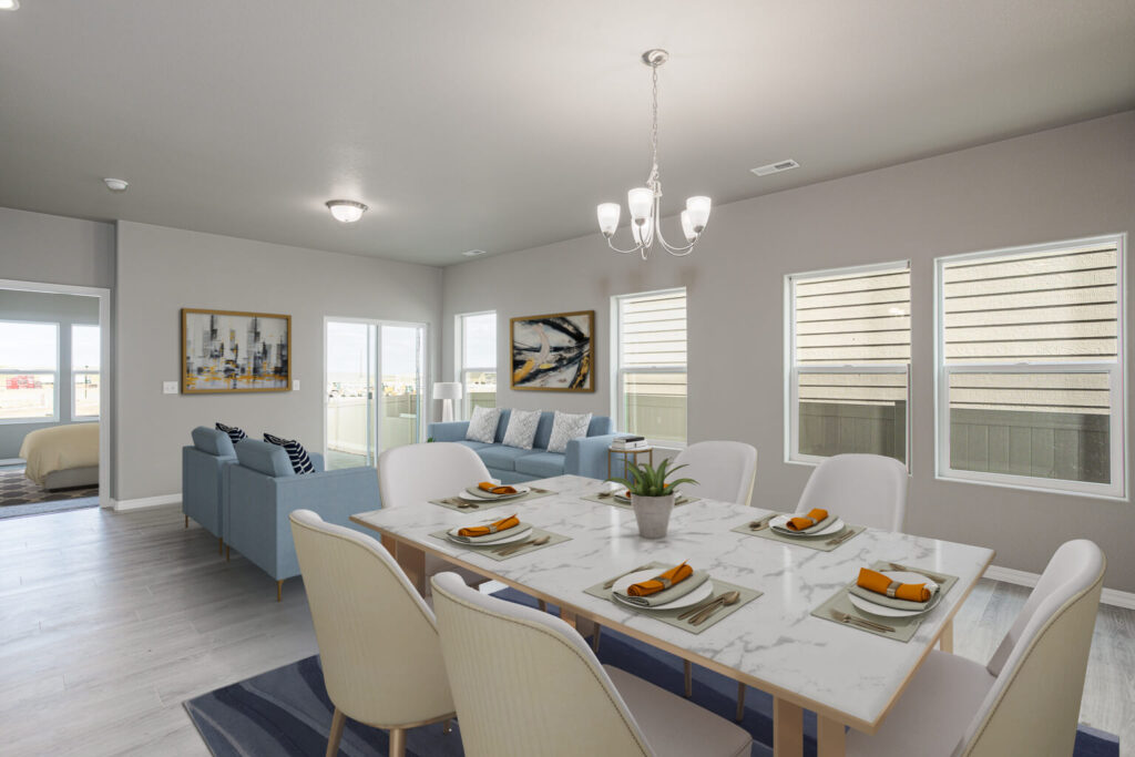 Dining area set with plates and napkins beside a living room with blue sofa and wall art.