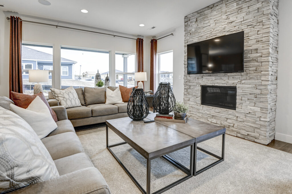 Cozy living room close-up with low coffee table, decorative vases, and stone fireplace with mounted TV.