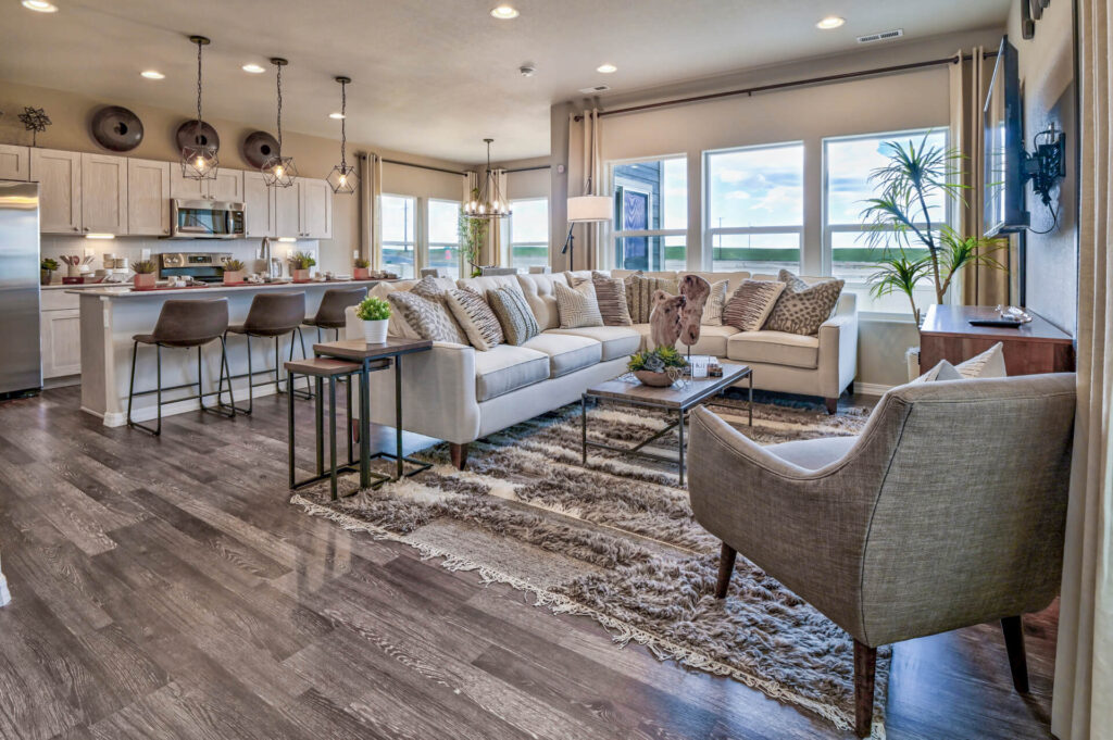 Open-plan living area with sectional sofa, kitchen island, and wide plank flooring