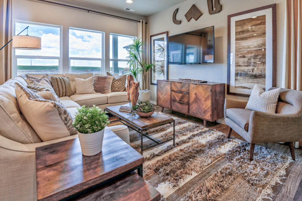 Cozy living room with L-shaped sofa, accent chair, wall-mounted TV, and decorative console