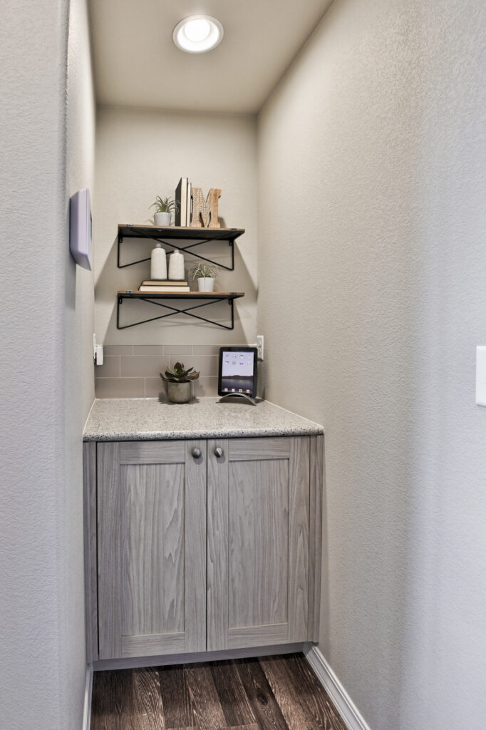 Small built-in cabinet alcove with two decorative wall shelves and countertop decor.