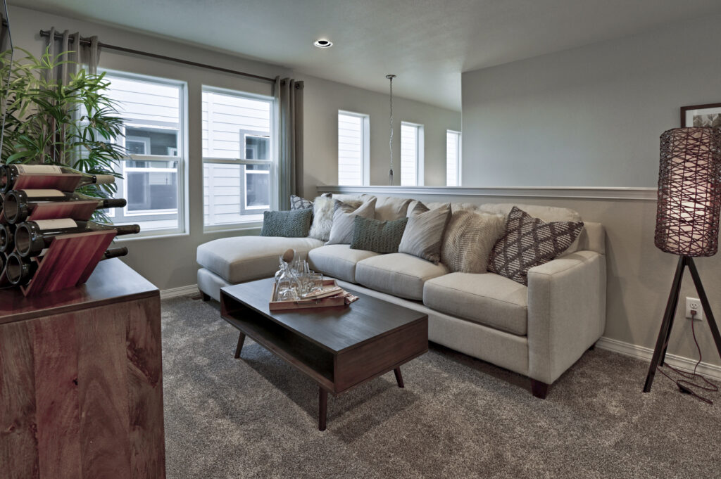 Cozy sofa seating area by windows with coffee table and floor lamp.