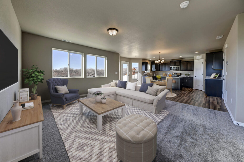 Open-concept living area with sectional sofa, armchair, coffee table, and large windows.