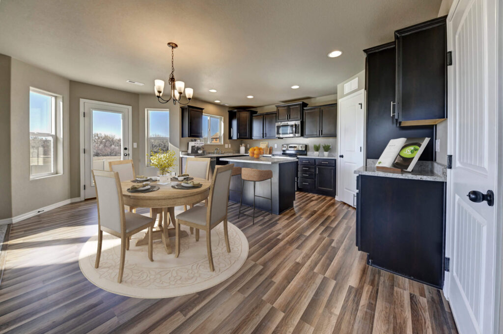 Kitchen and dining nook with round table, island seating, dark cabinets, and wood-look floors.