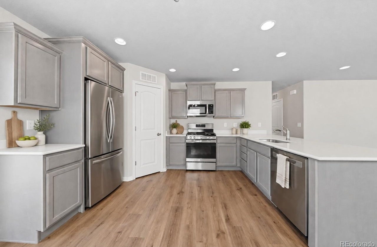 kitchen with gray shaker cabinets, stainless steel appliances, white countertops, and hardwood-look flooring